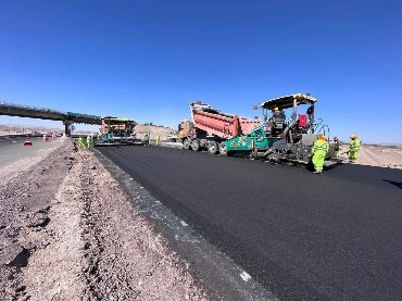 Cuadrilla y extendedora pavimentando la doble vía en Calama